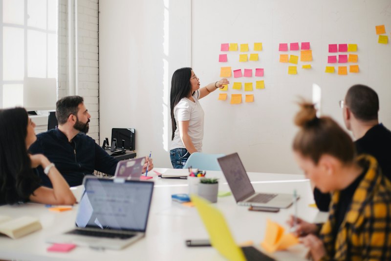 Team im Workshop vor einer Wand mit Haftnotizen
